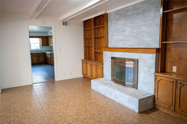 2206 Culbertson, Paris, TX 75460 - unfurnished living room with beamed ceiling, a sink, baseboards, light tile patterned floors, and a fireplace