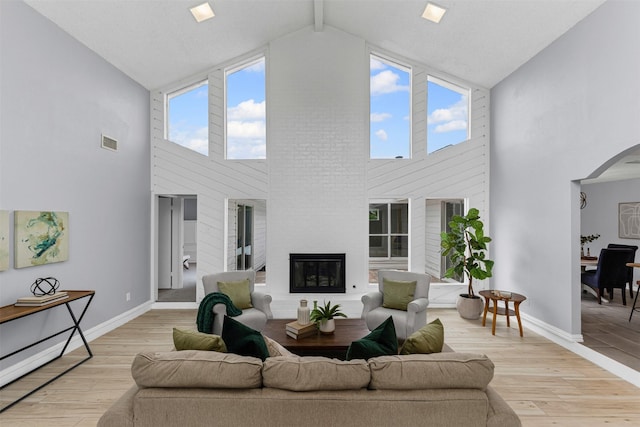 2100 Scarlet Oak Dr, Richardson, TX 75081 - living area featuring high vaulted ceiling, a large fireplace, light wood-type flooring, baseboards, and beam ceiling