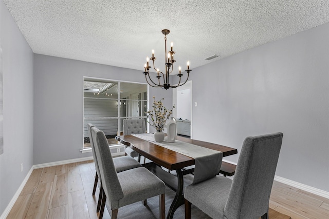 2100 Scarlet Oak Dr, Richardson, TX 75081 - dining area with a chandelier, light wood-style flooring, baseboards, and a textured ceiling