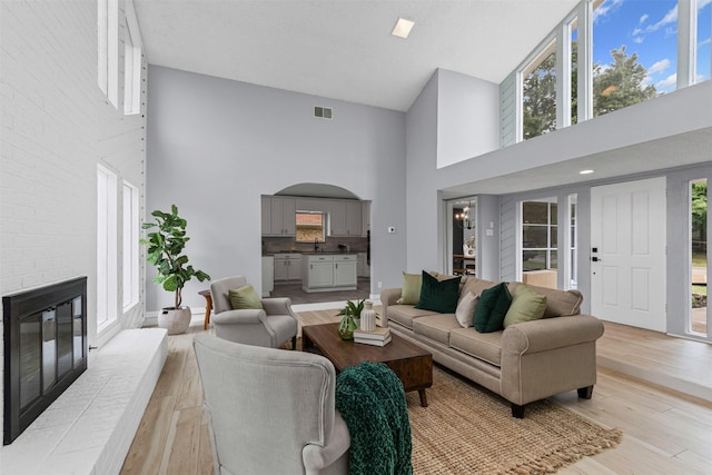 2100 Scarlet Oak Dr, Richardson, TX 75081 - living room with high vaulted ceiling, a fireplace, light wood-type flooring, and plenty of natural light