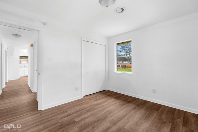 2541 Mecom Dr, Shreveport, LA 71104 - bathroom with wood finished floors, toilet, a sink, tub / shower combination, and wainscoting