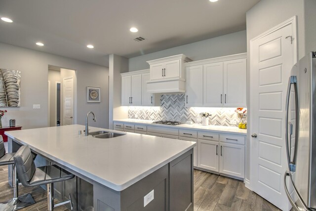 3609 Honey Suckle Ln, Little Elm, TX 75068 - kitchen with stainless steel appliances, a sink, dark wood-style floors, backsplash, and a center island with sink
