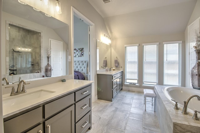 3609 Honey Suckle Ln, Little Elm, TX 75068 - bathroom with lofted ceiling, two vanities, a bath, tiled shower, and connected bathroom