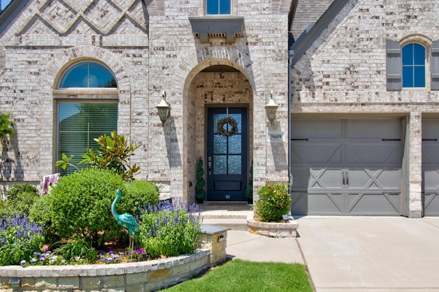 3609 Honey Suckle Ln, Little Elm, TX 75068 - view of exterior entry with brick siding, driveway, a garage, and stone siding