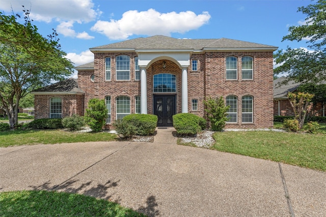 1300 Enchanted Rock Cir, Waco, TX 76712 - colonial-style house featuring a front lawn, brick siding, french doors, and a shingled roof