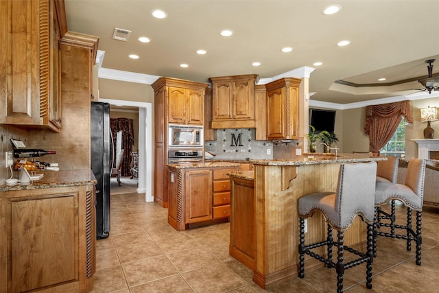 1300 Enchanted Rock Cir, Waco, TX 76712 - kitchen with ornamental molding, appliances with stainless steel finishes, a peninsula, recessed lighting, and decorative backsplash