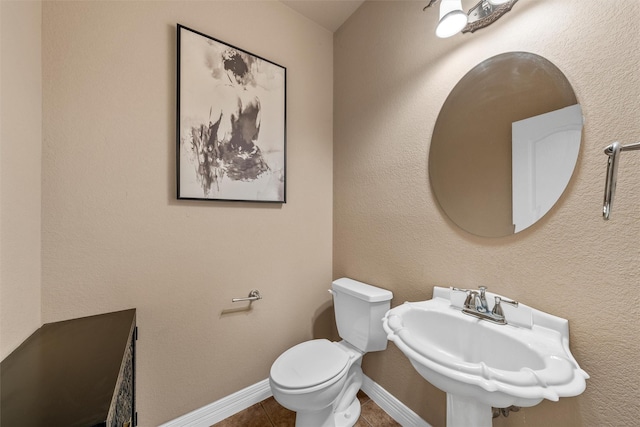 1300 Enchanted Rock Cir, Waco, TX 76712 - bathroom with tile patterned floors, toilet, a sink, and baseboards