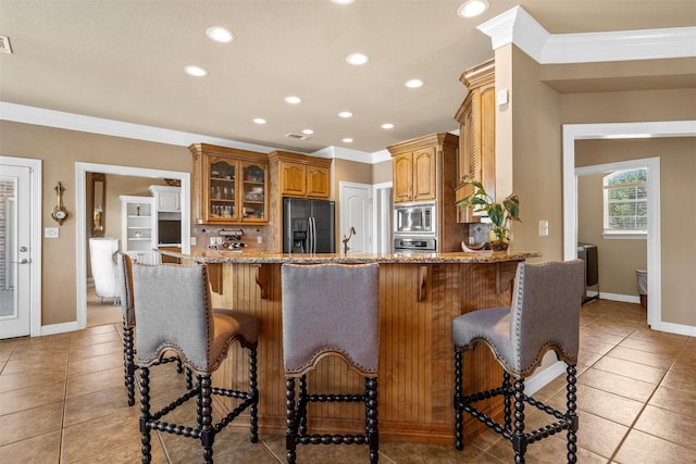 1300 Enchanted Rock Cir, Waco, TX 76712 - kitchen with stainless steel appliances, light tile patterned floors, a peninsula, glass insert cabinets, and light stone countertops