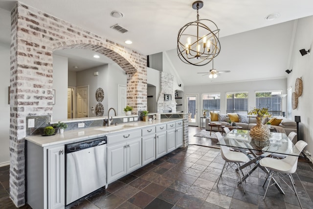 2398 April Sound Ln, Frisco, TX 75033 - kitchen with stainless steel dishwasher, arched walkways, stone tile flooring, a sink, and a chandelier