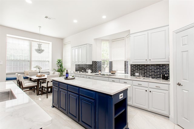 3700 Wagon Wheel Ct, Richardson, TX 75082 - kitchen with white cabinetry, decorative backsplash, a center island, blue cabinets, and recessed lighting
