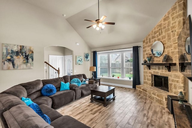 4323 Cherry Ln, Melissa, TX 75454 - living area featuring arched walkways, high vaulted ceiling, a ceiling fan, wood finished floors, and a stone fireplace