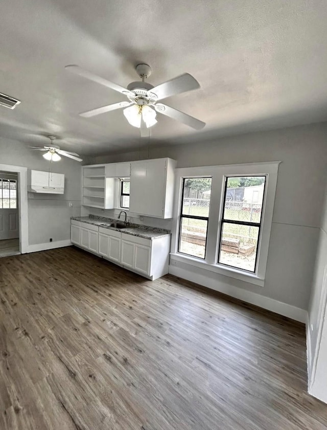 403 7th Ave, Mineral Wells, TX 76067 - kitchen with baseboards, white cabinetry, plenty of natural light, and wood finished floors