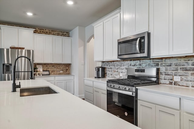2709 Madera Canyon Rd, Aubrey, TX 76227 - kitchen with appliances with stainless steel finishes, a sink, light countertops, white cabinets, and tasteful backsplash