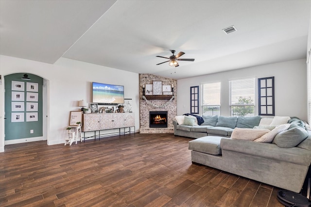2709 Madera Canyon Rd, Aubrey, TX 76227 - living area featuring a ceiling fan, dark wood-style flooring, a fireplace, arched walkways, and baseboards