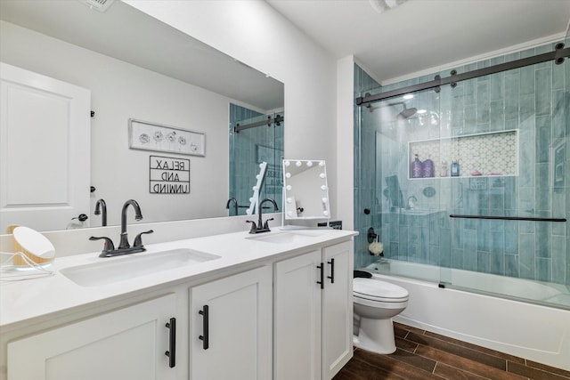 2709 Madera Canyon Rd, Aubrey, TX 76227 - full bath with toilet, wood finish floors, double vanity, and bath / shower combo with glass door
