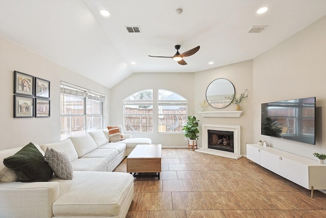 1689 Big Bend Dr, Lewisville, TX 75077 - living room with a ceiling fan, a fireplace with raised hearth, vaulted ceiling, recessed lighting, and baseboards