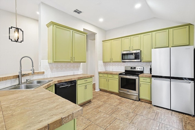 1689 Big Bend Dr, Lewisville, TX 75077 - kitchen featuring stainless steel appliances, green cabinets, a sink, backsplash, and vaulted ceiling