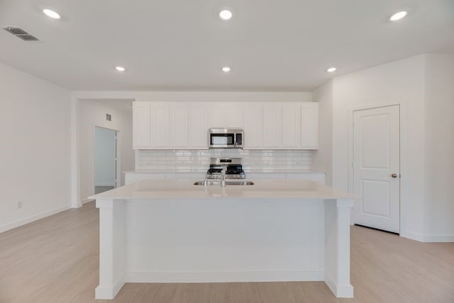 1301 Francesca Dr, Little Elm, TX 75068 - kitchen featuring stainless steel appliances, light countertops, light wood finished floors, tasteful backsplash, and recessed lighting