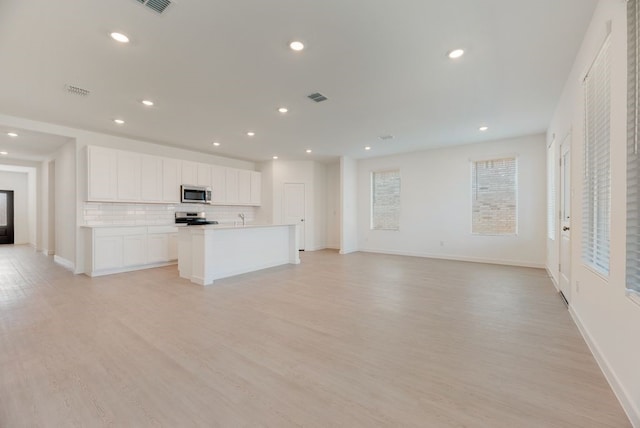 1301 Francesca Dr, Little Elm, TX 75068 - unfurnished living room featuring light wood-style flooring, recessed lighting, baseboards, and a sink