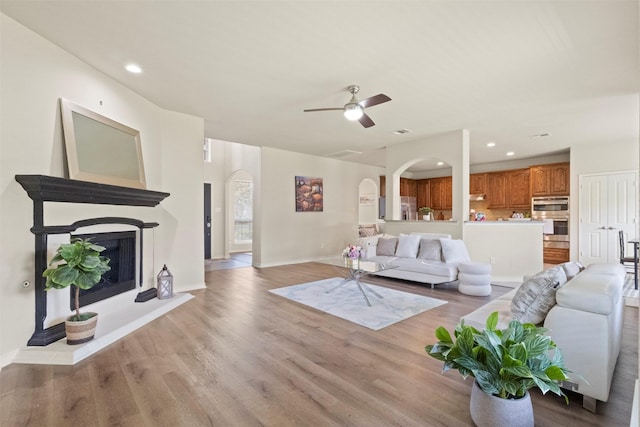 1713 Westfield Way, Allen, TX 75002 - living room with arched walkways, light wood-style floors, a ceiling fan, baseboards, and recessed lighting