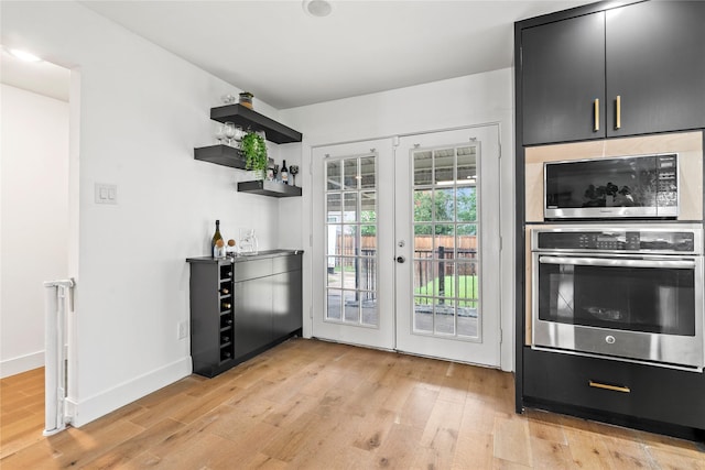 3412 Regal, Mesquite, TX 75149 - kitchen with appliances with stainless steel finishes, light wood-style flooring, french doors, open shelves, and dark cabinetry