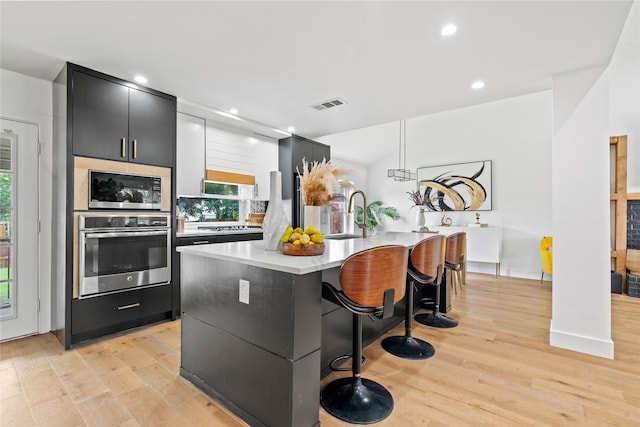 3412 Regal, Mesquite, TX 75149 - kitchen with stainless steel appliances, a sink, light countertops, light wood finished floors, and modern cabinets