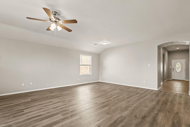 2004 Uvalde Dr, Forney, TX 75126 - empty room with arched walkways, vaulted ceiling, wood finished floors, and baseboards