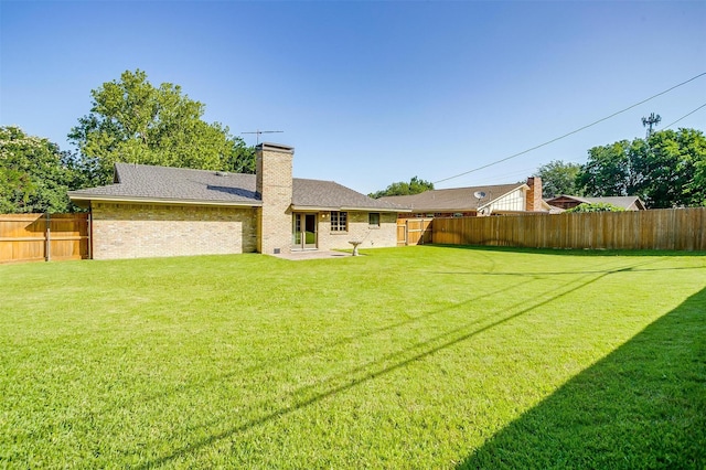 6417 Winifred Dr, Fort Worth, TX 76133 - back of house with a fenced backyard, a chimney, and brick siding