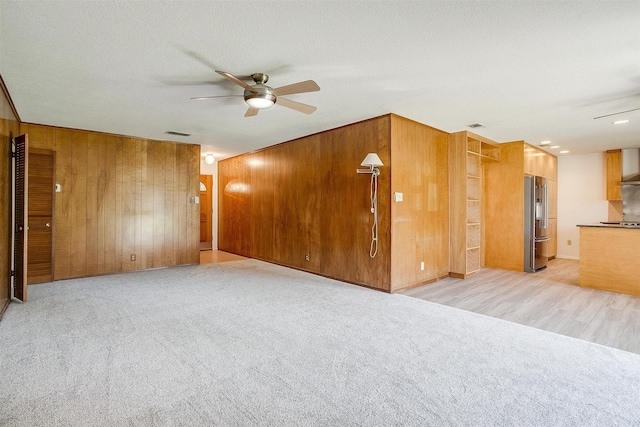 6417 Winifred Dr, Fort Worth, TX 76133 - spare room featuring a ceiling fan, wooden walls, and light carpet