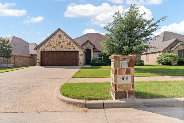 906 Joshua Ct, Granbury, TX 76048 - french country inspired facade featuring driveway, an attached garage, a front lawn, and stone siding
