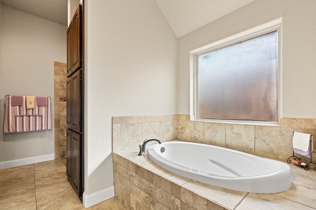 906 Joshua Ct, Granbury, TX 76048 - bathroom featuring a bath, lofted ceiling, tile patterned flooring, and baseboards
