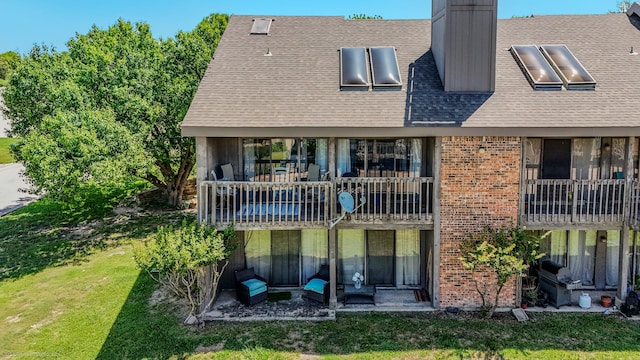 1006 Signal Ridge Pl, Rockwall, TX 75032 - rear view of property featuring brick siding, a yard, a shingled roof, a chimney, and a patio area