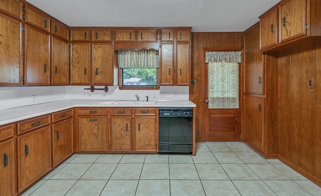 3732 N 24th St, Waco, TX 76708 - kitchen with black dishwasher, brown cabinetry, light countertops, a sink, and wooden walls