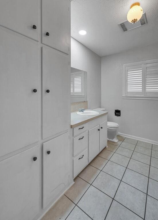 3732 N 24th St, Waco, TX 76708 - bathroom with vanity, tile patterned floors, toilet, a textured ceiling, and baseboards