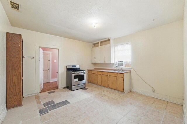 2610 Columbus Ave, Fort Worth, TX 76164 - kitchen with stainless steel range with gas cooktop, light countertops, a sink, cooling unit, and baseboards