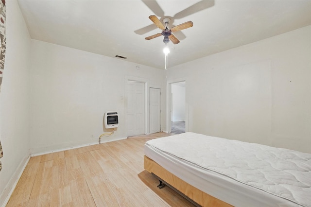 2610 Columbus Ave, Fort Worth, TX 76164 - bedroom featuring wood finished floors, heating unit, baseboards, and a ceiling fan