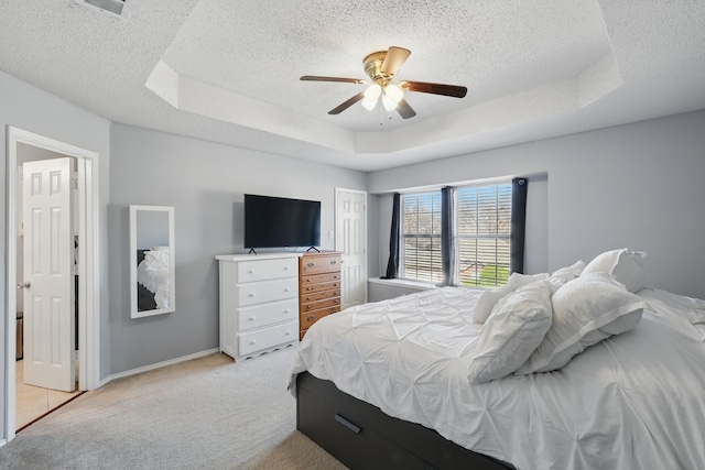 1512 Pacific Pl, Fort Worth, TX 76112 - bedroom featuring light colored carpet, a textured ceiling, a tray ceiling, a ceiling fan, and baseboards
