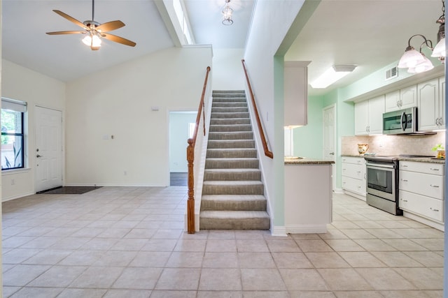 1112 Forest Creek St, Benbrook, TX 76126 - kitchen featuring stainless steel appliances, decorative backsplash, light tile patterned floors, a ceiling fan, and white cabinetry