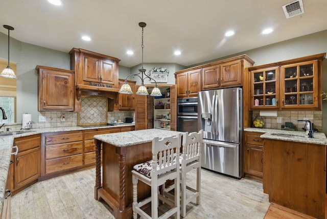 5925 Compass Way, Bluff Dale, TX 76433 - kitchen featuring stainless steel appliances, a sink, brown cabinets, light wood finished floors, and recessed lighting
