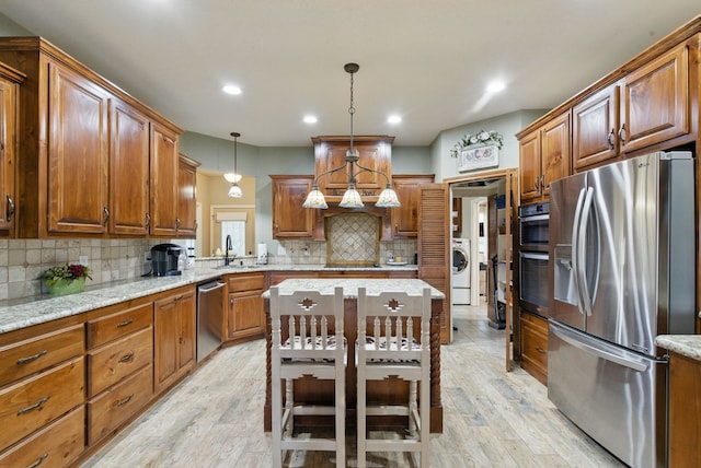 5925 Compass Way, Bluff Dale, TX 76433 - kitchen with stainless steel appliances, a sink, backsplash, washer / dryer, and light wood finished floors