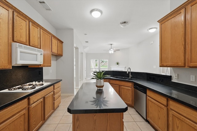 3812 Ridgemont Ln, Denton, TX 76210 - kitchen featuring white appliances, dark countertops, a sink, and light tile patterned flooring