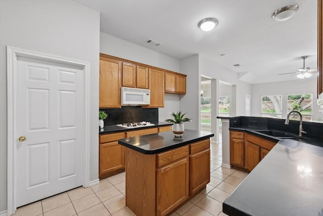 3812 Ridgemont Ln, Denton, TX 76210 - kitchen with white appliances, a sink, light tile patterned flooring, dark countertops, and a ceiling fan