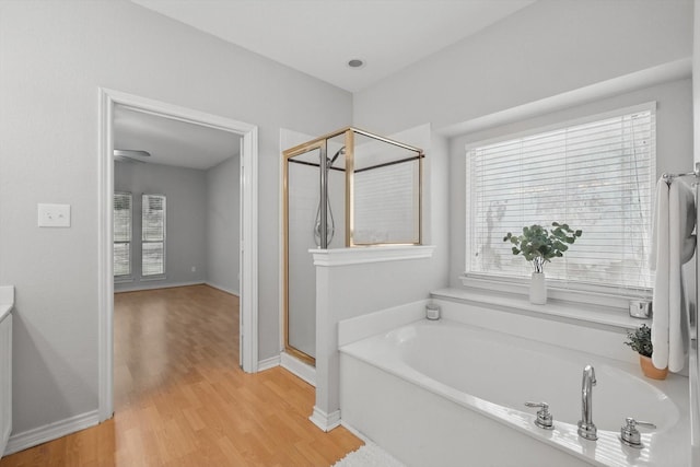 3812 Ridgemont Ln, Denton, TX 76210 - bathroom featuring a garden tub, a stall shower, plenty of natural light, and wood finished floors