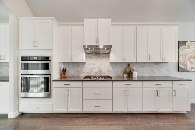 11578 Barcelona Ln, Frisco, TX 75035 - kitchen featuring under cabinet range hood, stainless steel appliances, dark countertops, and white cabinets