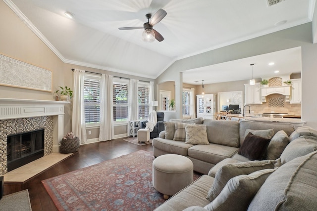 1300 Millers Creek Dr, Prosper, TX 75078 - living area with a ceiling fan, a tile fireplace, lofted ceiling, dark wood finished floors, and crown molding