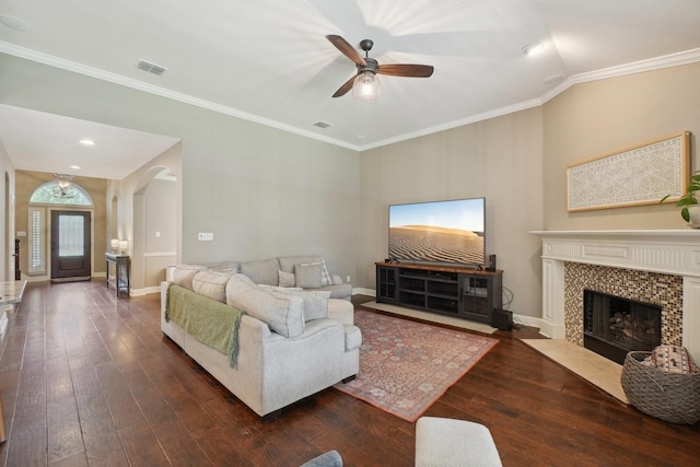 1300 Millers Creek Dr, Prosper, TX 75078 - living area featuring a ceiling fan, wood-type flooring, a tiled fireplace, ornamental molding, and arched walkways