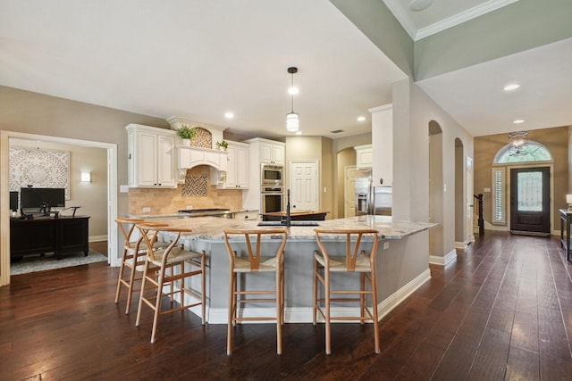 1300 Millers Creek Dr, Prosper, TX 75078 - kitchen with appliances with stainless steel finishes, dark wood-style flooring, baseboards, backsplash, and light stone counters