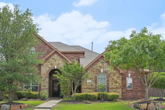 1300 Millers Creek Dr, Prosper, TX 75078 - view of front of property with stone siding, a shingled roof, and brick siding