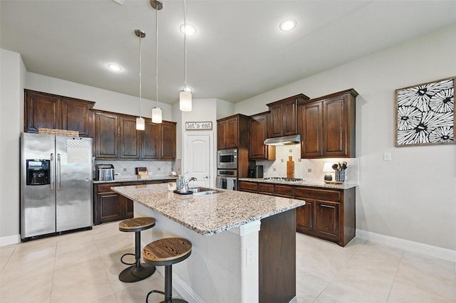 528 England St, Fate, TX 75189 - kitchen with appliances with stainless steel finishes, under cabinet range hood, a sink, dark brown cabinets, and tasteful backsplash