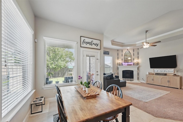 528 England St, Fate, TX 75189 - dining area with healthy amount of natural light, a ceiling fan, a fireplace with raised hearth, and light tile patterned flooring